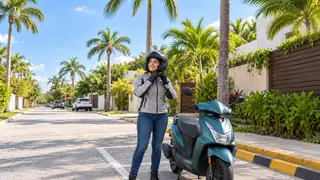 Motociclista con casco junto a una motoneta estacionada en una calle ilustrativa de Quintana Roo.